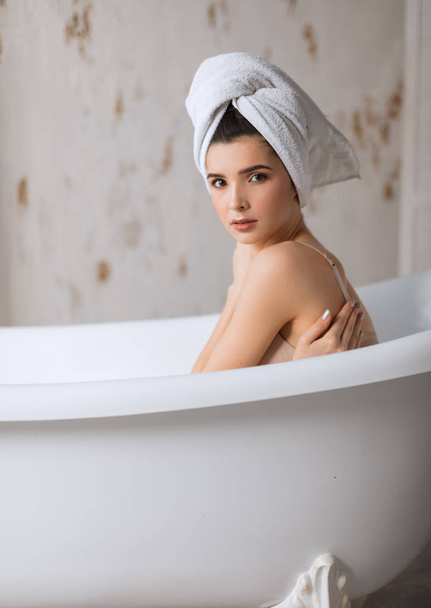 Relaxed young woman laying in bathtub - Foto, Imagen