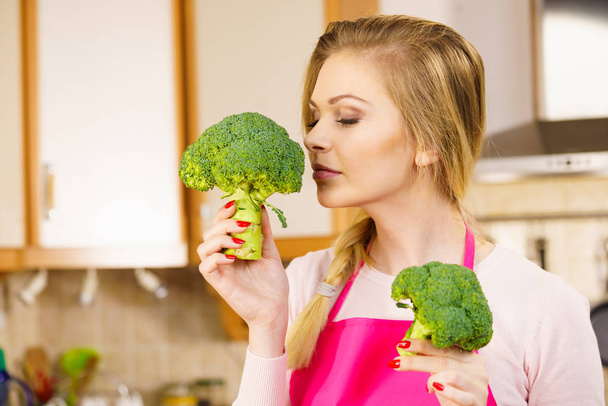 Happy young woman holding raw green vegetable broccoli. Natural organic healthy food concept. - Foto, Imagem