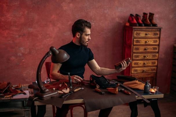 shoemaker holding a brush for cleaning shoes - 写真・画像