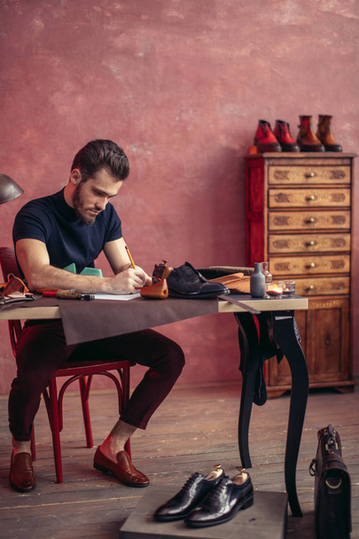 young creative shoemaker designing a new stylish model of shoes - Foto, Imagen