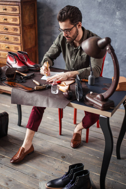 young talented man conceptualizing and developing own footwear design - 写真・画像