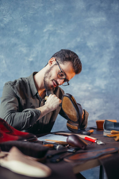 hardworking guy peel off the sole of leather footwear - Фото, изображение