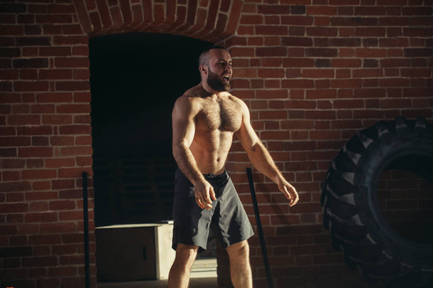 Young caucasian man working out with battle ropes at a gym - Foto, Imagen