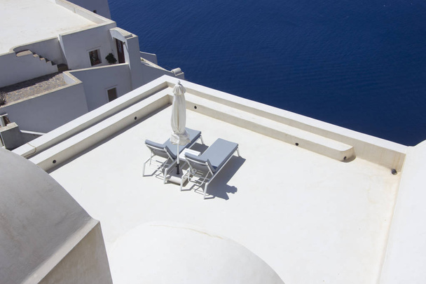 Terrasse am Meer mit Liegestühlen in fira santorini, Griechenland - Foto, Bild