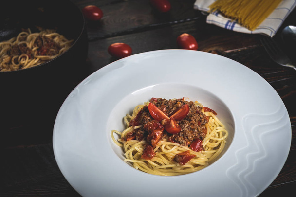 Hagyományos olasz tészta bolognai spagetti, darált hús és a paradicsom, a sötét fa asztal - Fotó, kép
