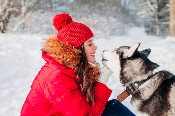 Young woman playing with her Husky dog in winter park - Фото, зображення