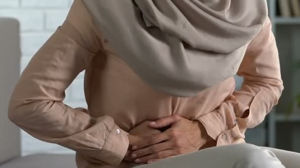 Pretty lady in hijab feeling sharp abdominal pain, premenstrual syndrome, health - Felvétel, videó