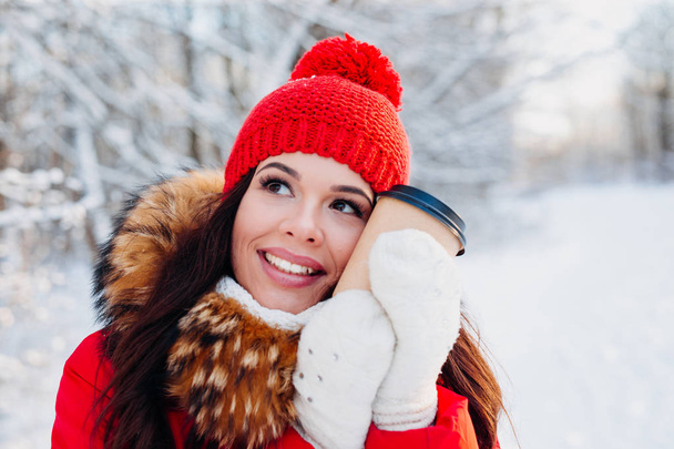 Portrait of young beautiful woman on winter outdoor background. Drinking coffee and enjoying life. - Foto, Bild