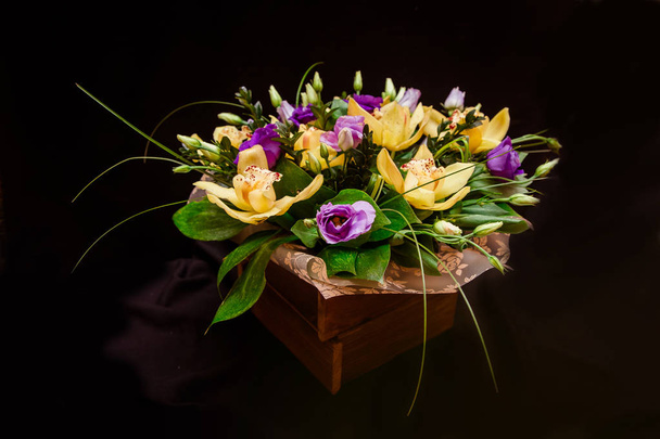 Букет желтых орхидей в коробке с деревом
 - Фото, изображение