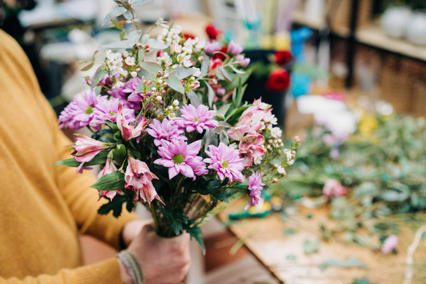 Muž květinářství dělá květiny kytice a balení v balení papíru - Fotografie, Obrázek