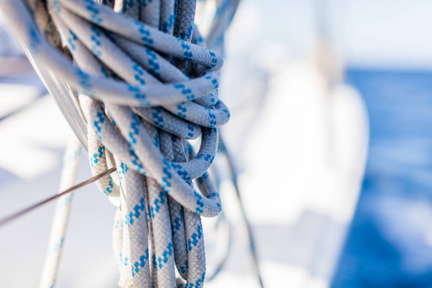 Detail of a mooring rope placed on sailing boat yacht desk. Leasure activities and extreme sport. Low depth of focus. - Photo, image