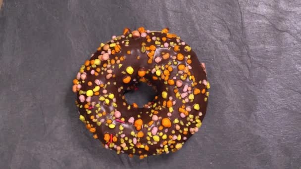 Makea donitsi pyörii tummalla pohjalla. Perinteinen amerikkalainen makeus
 - Materiaali, video
