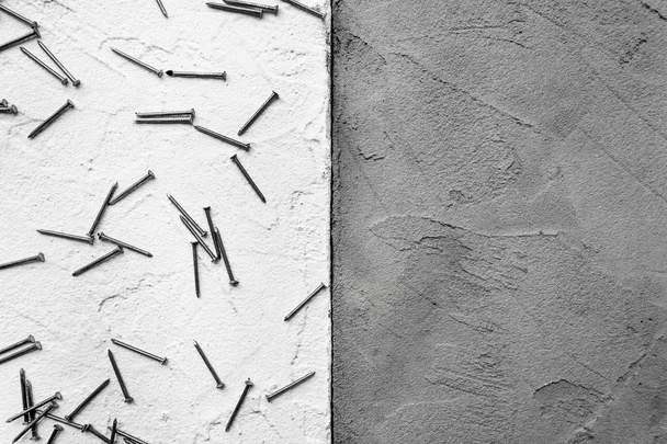white and gray abstract textured plaster on the wall with scattered nails - Photo, image
