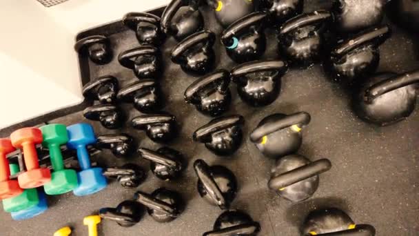 Black kettlebells in the fitness center or gym. Small to big and heavy. It's a 4K video and a top view. - Footage, Video