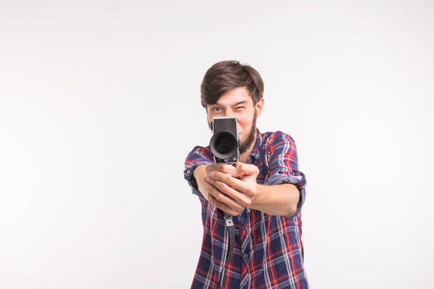 Funny people, photo and vintage concept - young man using vintage camera on white background - Foto, immagini