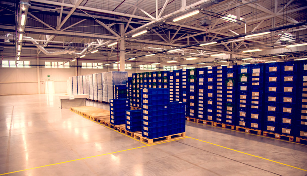 Warehouse with boxes at a modern plant in a production workshop with lighting and ventilation. Logistics - Photo, Image