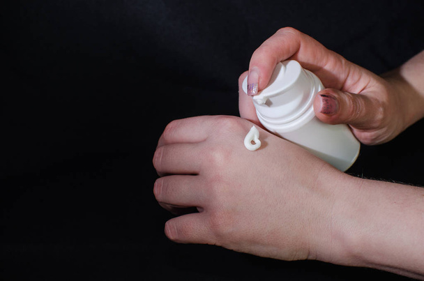 Smear cream on woman hand. Lotion for face or body. - Φωτογραφία, εικόνα