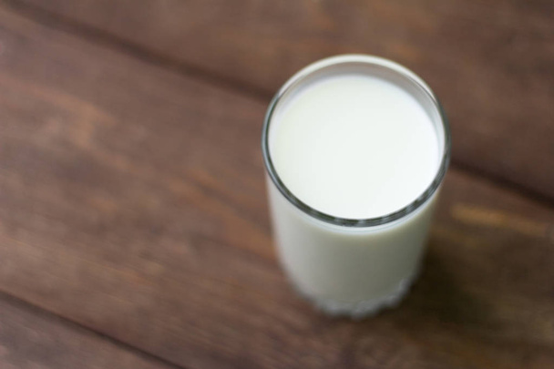 vaso de leche fresca de vaca sobre fondo de madera
 - Foto, imagen