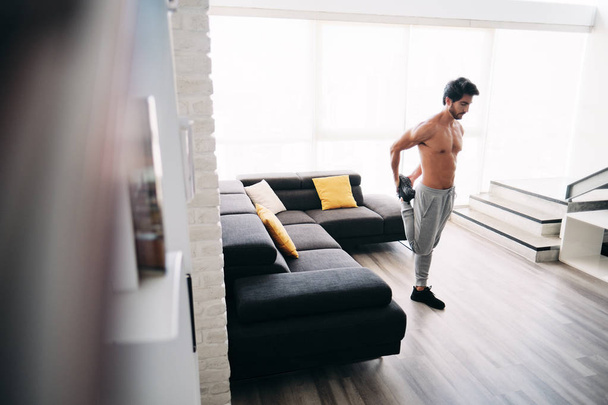 Aikuisen miehen kuntoilu kotona venyttely lihakset ennen harjoittelua
 - Valokuva, kuva