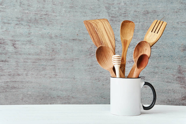 Kitchen utensils in ceramic cup on a gray background, copy space - Fotó, kép