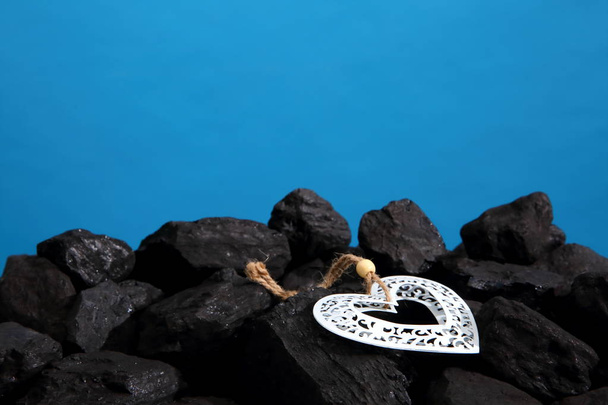 close-up shot of heart with pile of coal on blue - Photo, Image