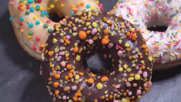 süße Donuts, die sich auf einem dunklen Hintergrund drehen. traditionelle amerikanische Süße - Filmmaterial, Video