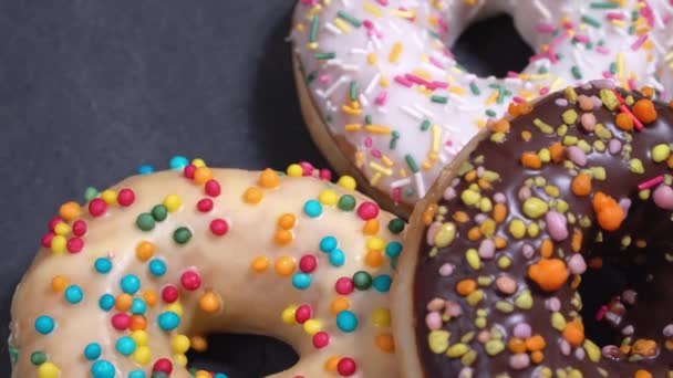 süße Donuts, die sich auf einem dunklen Hintergrund drehen. traditionelle amerikanische Süße - Filmmaterial, Video