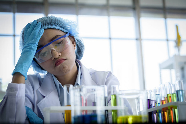 Ασιάτισσα νεαρή κοπέλα επιστήμονας φοιτητής αισθάνεται λυπημένος έρευνα και μάθηση σε ένα εργαστήριο. - Φωτογραφία, εικόνα