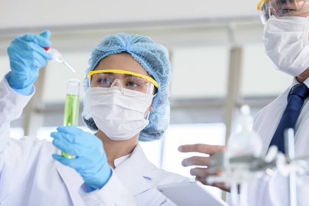 Junge asiatische Wissenschaftlerinnen und Wissenschaftler forschen und lernen mit leitenden Wissenschaftlern in einem Labor. - Foto, Bild