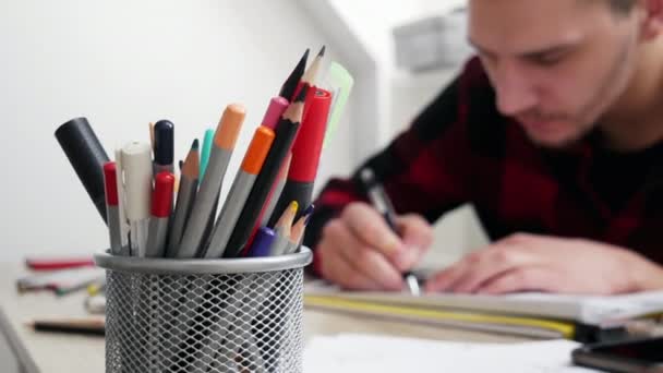 Caja de lápiz en el fondo borroso artista hombre dibuja un boceto
 - Imágenes, Vídeo