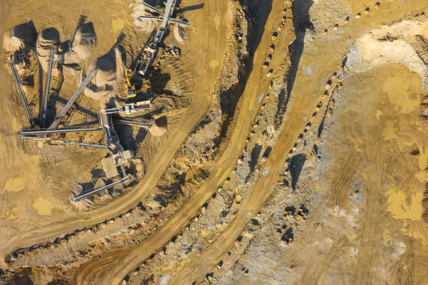 Vista aérea de la cantera minera a cielo abierto con mucha maquinaria. Vista industrial del lugar desde arriba. Foto capturada con dron
. - Foto, Imagen