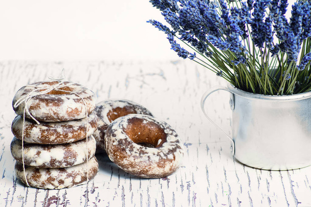 sweet gingerbread cookies in white glaze, in an aluminum mug a bouquet of lavender flowers - Photo, Image