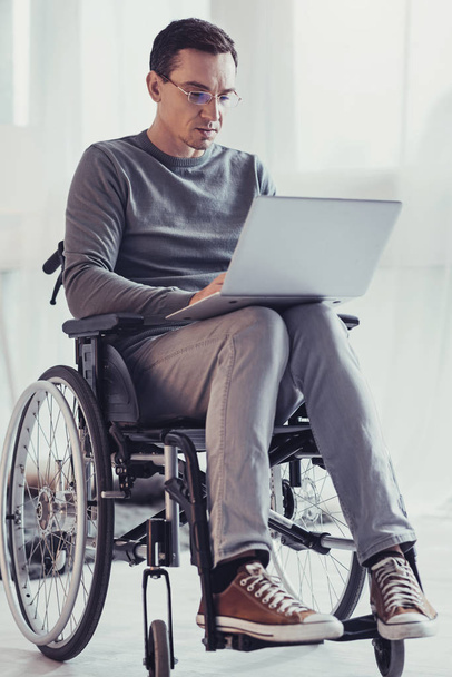 Serious handicapped man focusing on work - Φωτογραφία, εικόνα