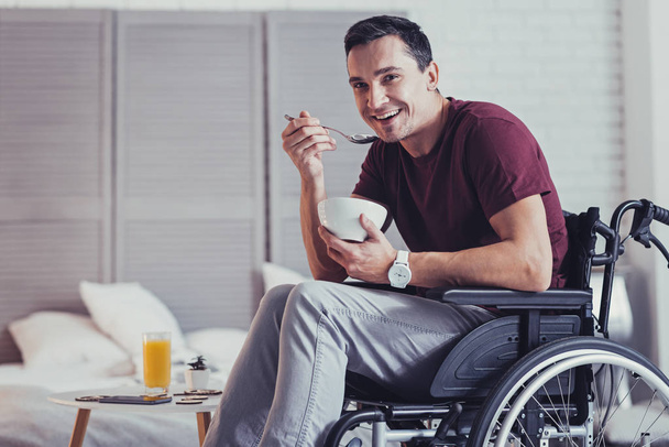 Pleasant handicapped man having breakfast - Fotó, kép