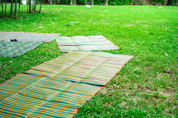 Asian mat on the grass ground in the outdoor park without people. - Photo, Image