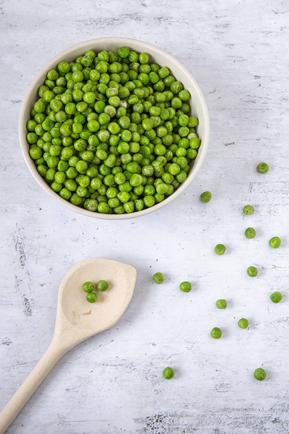 Green peas in a plate on the kitchen table. Produce. Light background. Sprouts - Foto, Bild