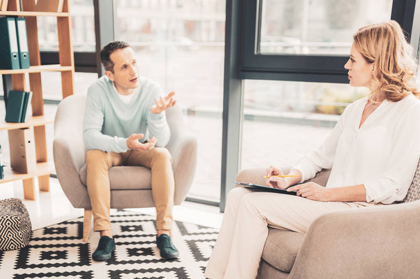 Anxious man explaining his problems to psychotherapist - Photo, Image