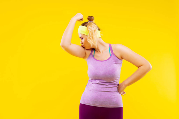 Spor yaptıktan sonra kolunu öpmeye komik sarışın kadın - Fotoğraf, Görsel
