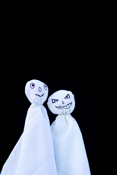 Decoración para Halloween. Dos figuras fantasmas sobre fondo negro. Decoración hecha a mano para la fiesta. - Foto, imagen
