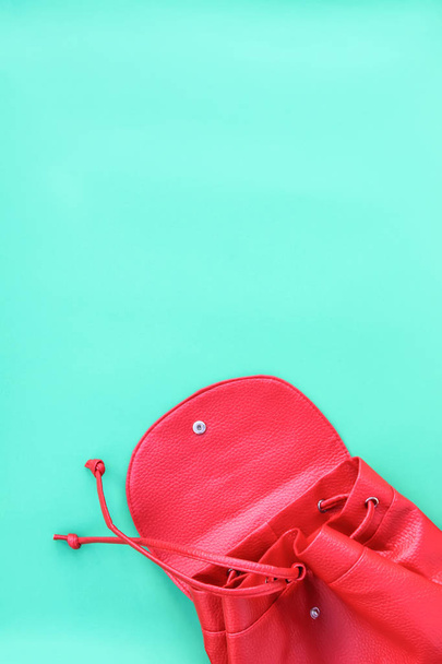 Κόκκινη άδεια τσάντα για σχολικό εξοπλισμό σε μαλακό παστέλ μπλε φόντο. - Φωτογραφία, εικόνα