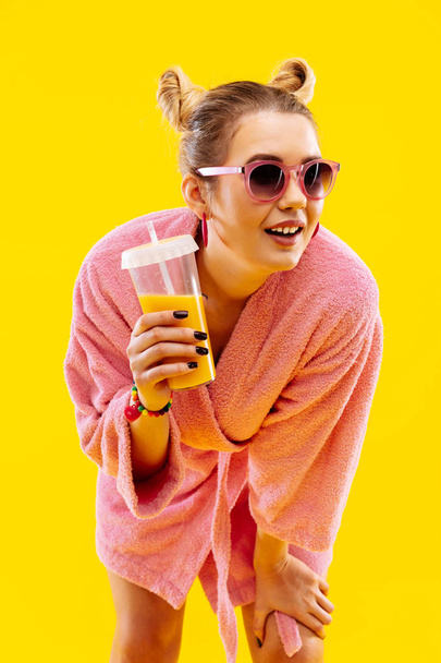 Cheerful blonde-haired woman holding her morning orange juice - Фото, изображение