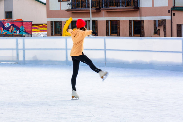 Uma garota jovem e magra na patinação artística ao ar livre em uma pista de patinação 2019
 - Foto, Imagem