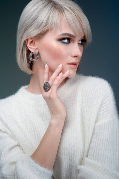 Beautiful blonde with luxurious silver jewelry. Woman wears silver jewelry - Фото, зображення