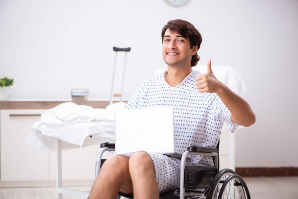 Joven hombre guapo en silla de ruedas en el hospital
  - Foto, Imagen