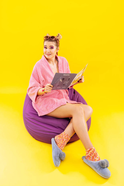 Young woman wearing home clothes reading fashion magazine - Zdjęcie, obraz