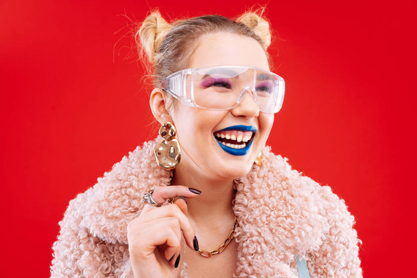 Cheerful woman with blue lips and pink eye shades laughing - Fotografie, Obrázek