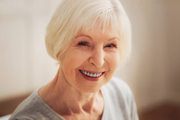 Happy elderly wife having facial wrinkles while smiling broadly - Фото, изображение