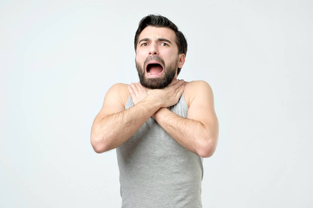 Ισπανικά άνδρες αγγίζει το λαιμό που ήταν άρρωστες - Φωτογραφία, εικόνα