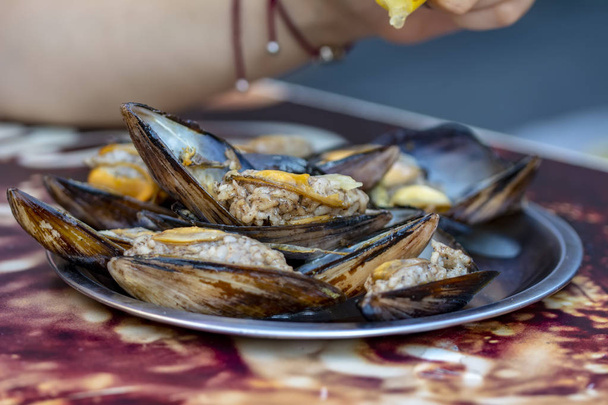 Woman eating seafood in a restaurant. Steamed mussels in white wine sauce. Food Concept - Photo, Image
