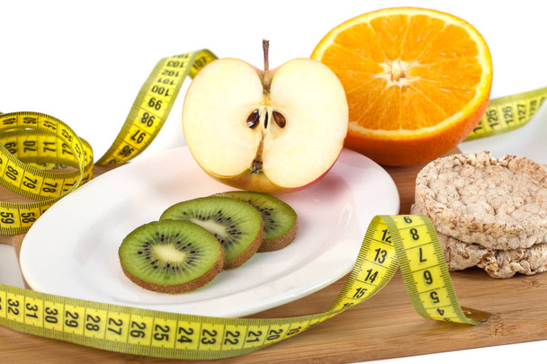 Fruta grave en tablero de madera con medición aislada en alimentos blancos y saludables
. - Foto, imagen